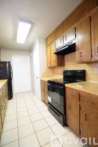 A kitchen with wooden cabinets and black appliances.