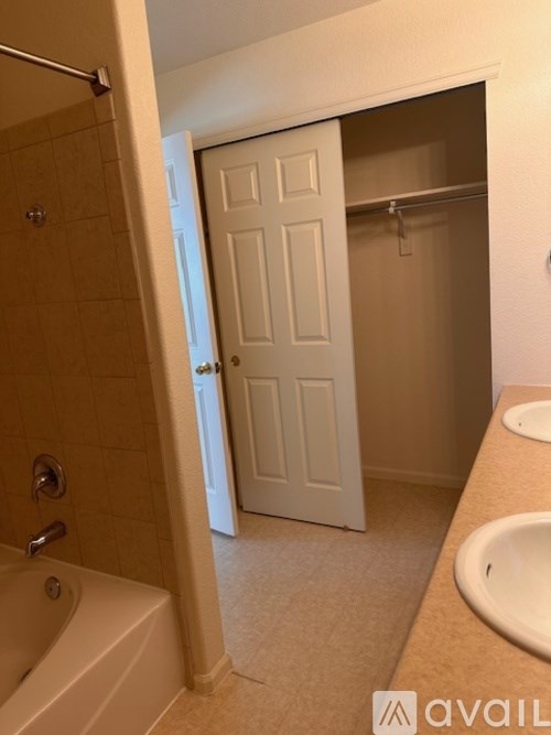 A bathroom with a tub, sink and door.