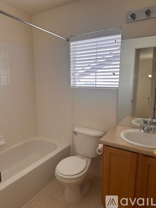 A white toilet sits next to a bathtub in a bathroom.