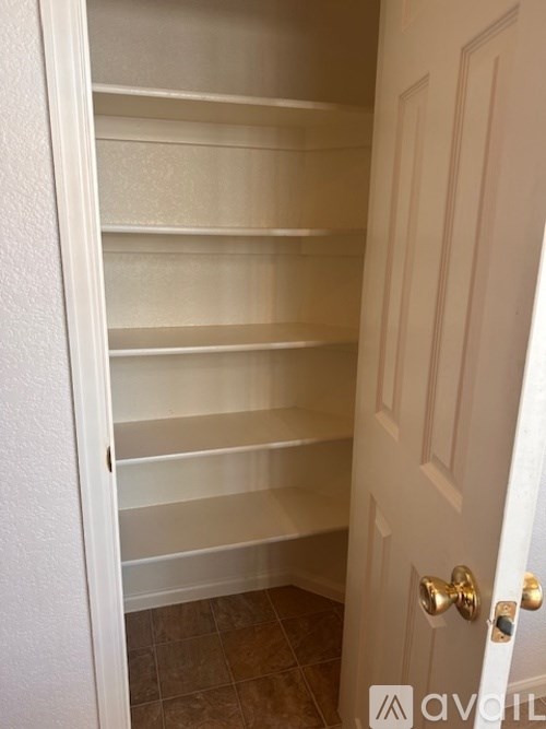 Empty white shelves in a white closet.
