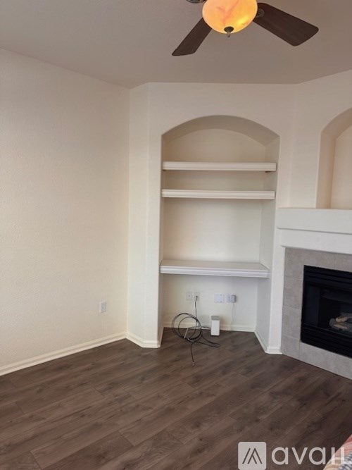 A room with a fireplace and a ceiling fan.