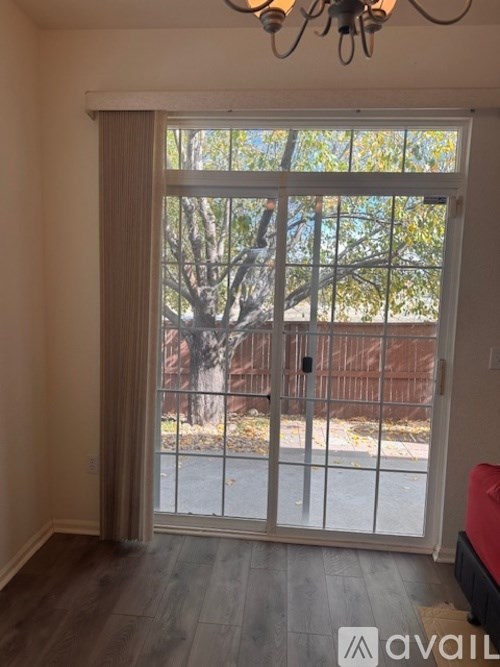 A room with a sliding glass door leading to a backyard.