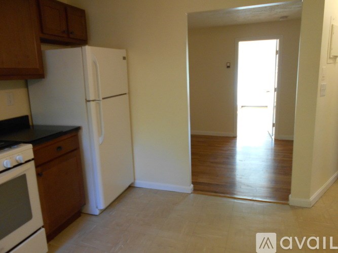 A kitchen with a white refrigerator and black countertops.