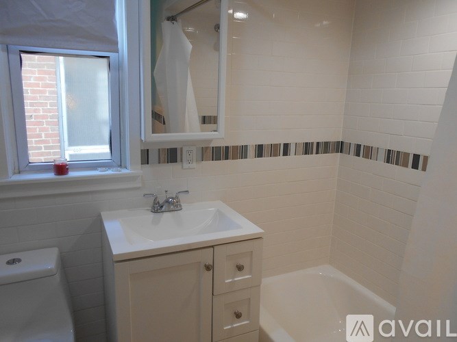 A bathroom with a white sink and a window.