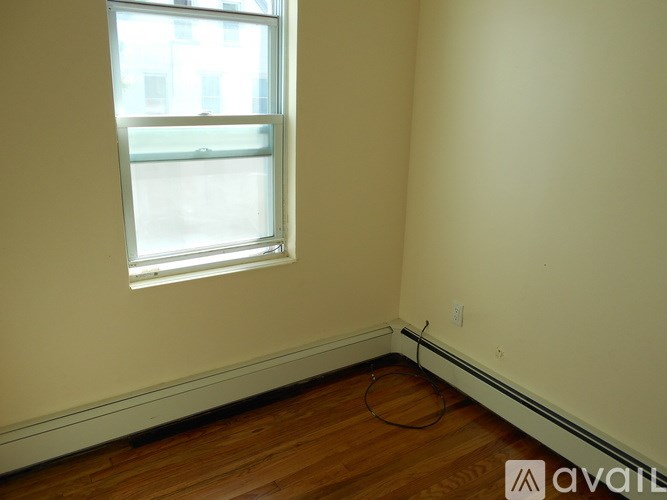 A room with a window and wooden flooring.