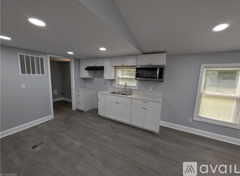 A kitchen with white cabinets and a microwave above the stove.