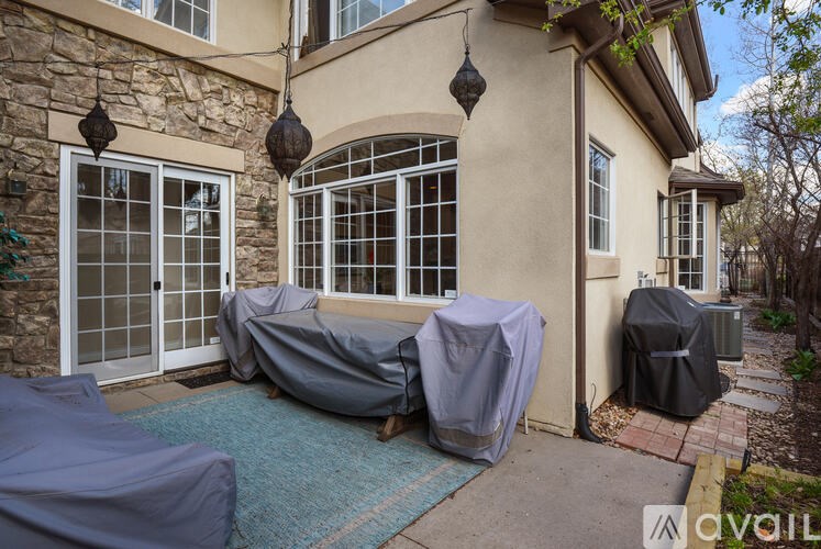 A house with a covered patio and a stone wall.