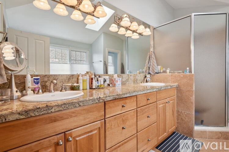 A bathroom with a sink, mirror, and wooden cabinets.