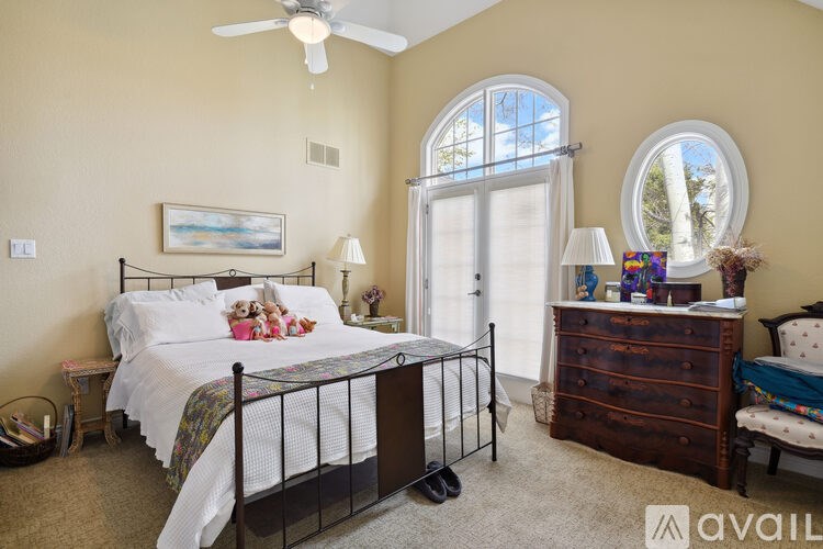 A bedroom with a bed, dresser, and window.