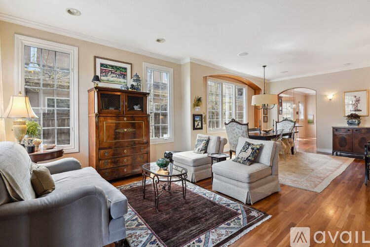 A living room with a grey couch, a wooden cabinet, and a rug.