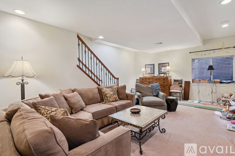 A living room with a brown couch and a coffee table.