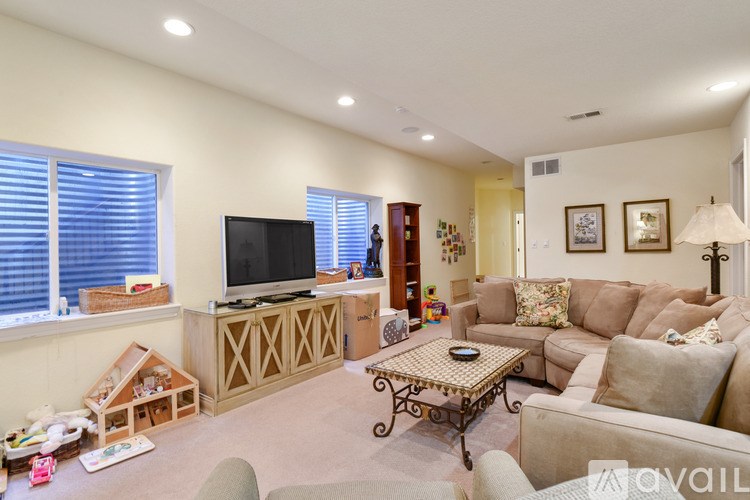 A living room with a television, couches, and a coffee table.