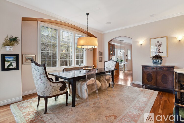 A dining room with a table and chairs.