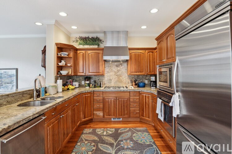 A kitchen with wooden cabinets and a stainless steel refrigerator.