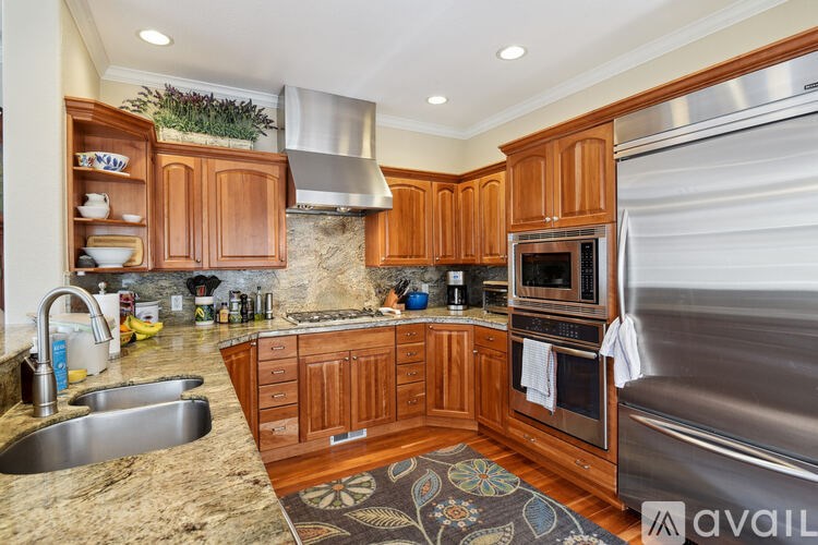A kitchen with wooden cabinets and a stainless steel refrigerator.