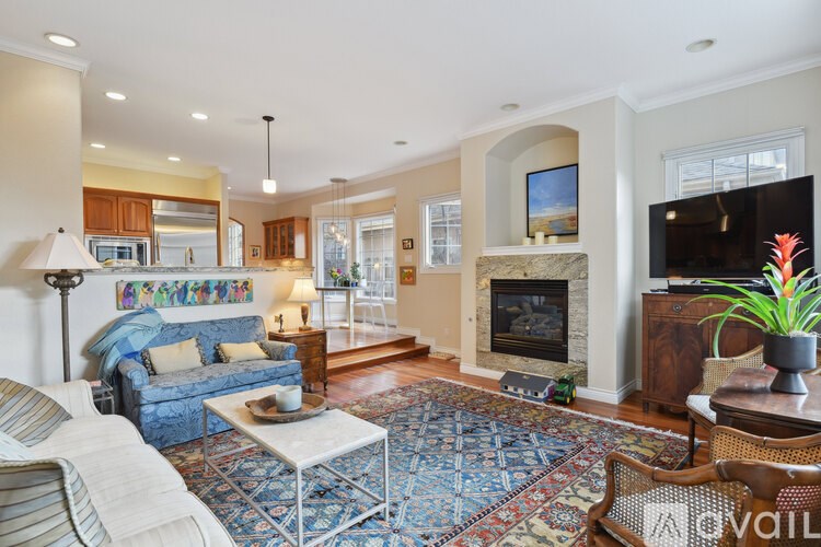 A living room with a fireplace and a blue couch.