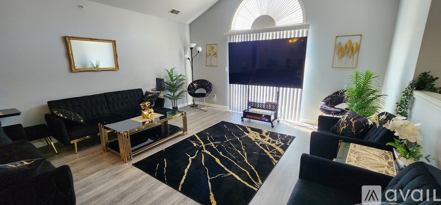 A living room with black furniture and a large mirror on the wall.