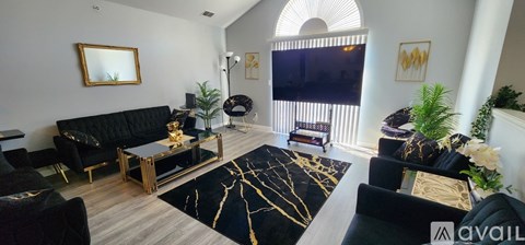 A living room with black furniture and a large mirror on the wall.