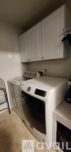 A white oven with a black control panel is in a kitchen with white cabinets.