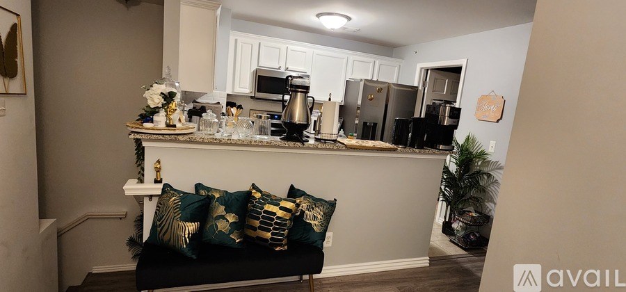 A kitchen with a black couch and a white counter.