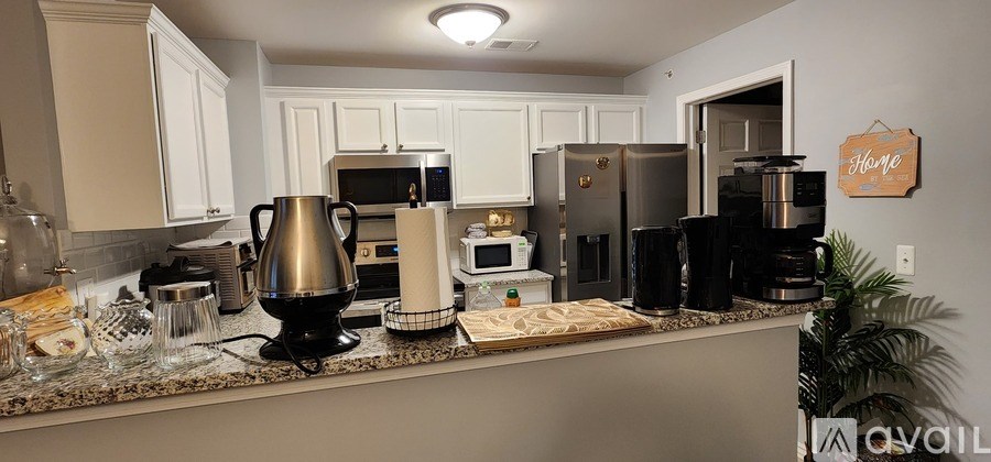 A kitchen with white cabinets and a granite countertop.