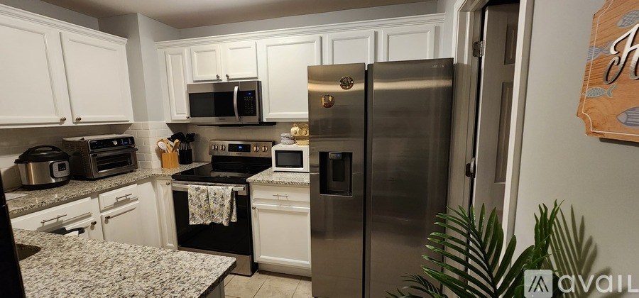 A kitchen with a black stove top oven and a silver refrigerator.
