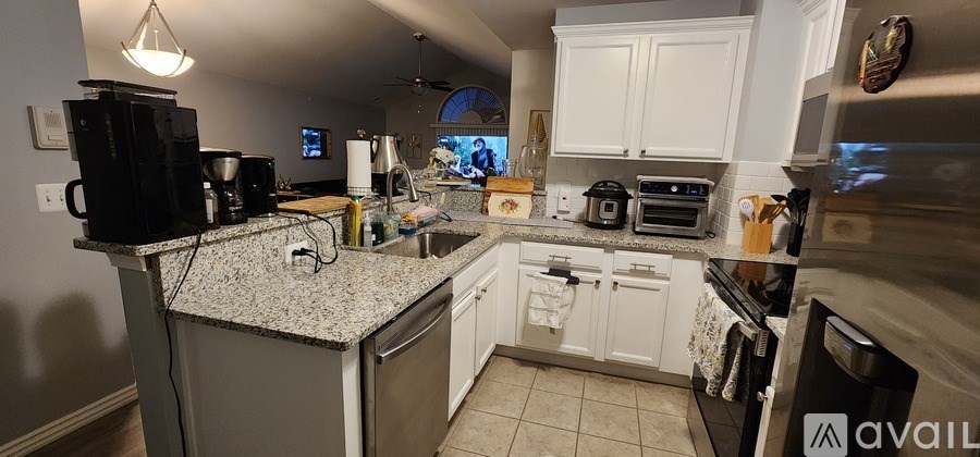 A kitchen with granite countertops and white cabinets.