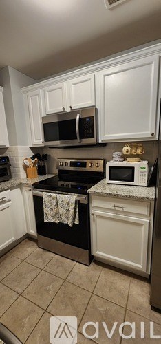 A kitchen with white cabinets and a black stove top oven.