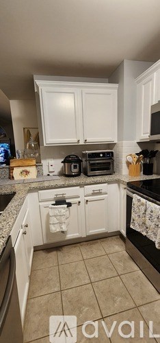 A kitchen with white cabinets and a black stove top.