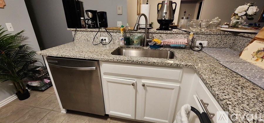 A kitchen with granite countertops and a stainless steel dishwasher.