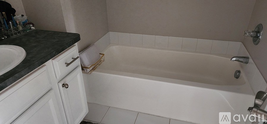 A white bath tub sits in a bathroom next to a sink.
