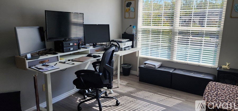A home office with a desk, chair, and computer monitors.