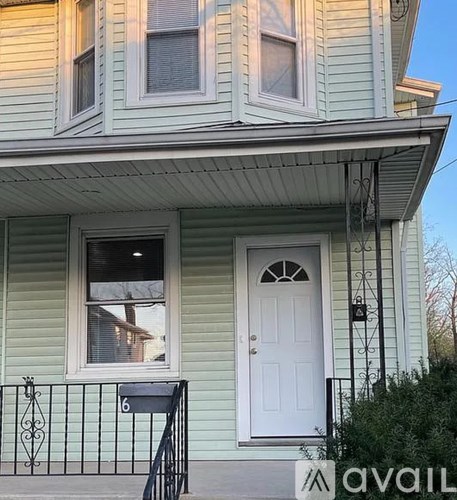 A house with a white door and a mailbox number 6.