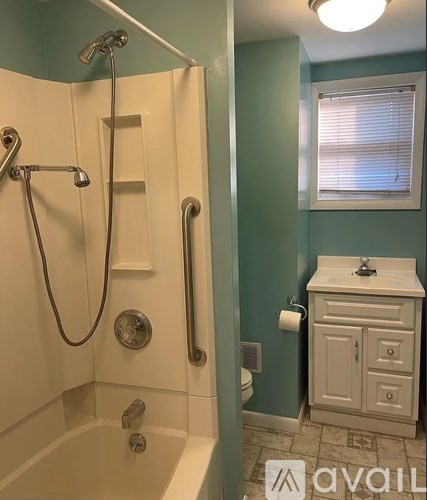 A bathroom with a white tub and a white sink.