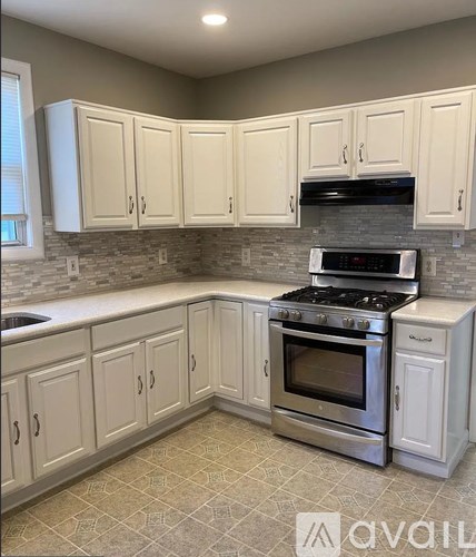A kitchen with white cabinets and a black stove top oven.