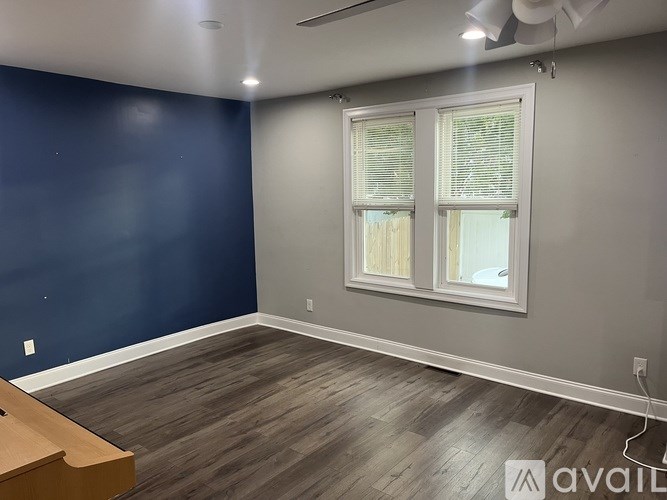 A room with a window and a wooden floor.