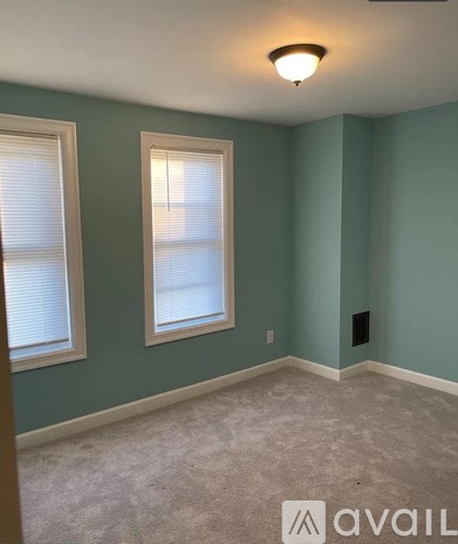 A room with a window and a light on the ceiling.