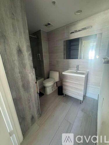 A bathroom with a toilet, sink, and shower.