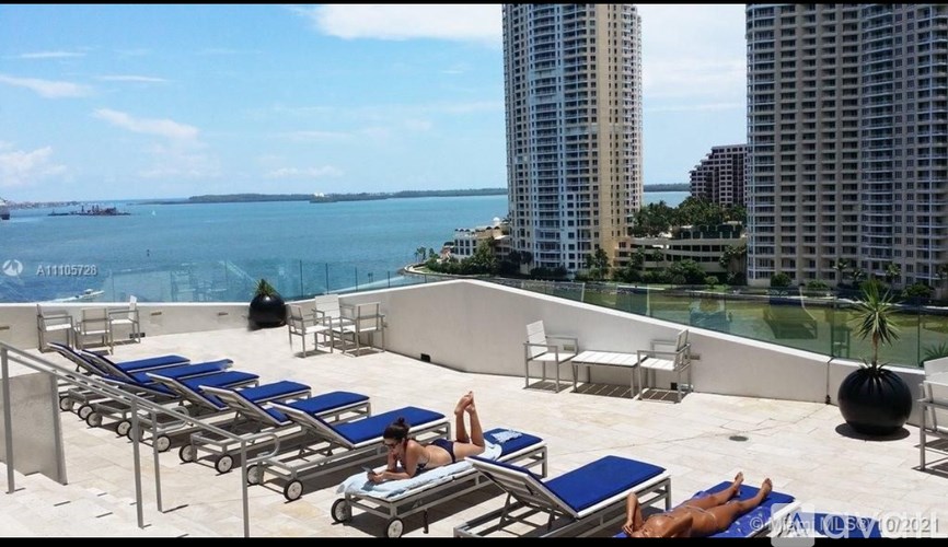 A man is sitting at a table in a room with a large open door.