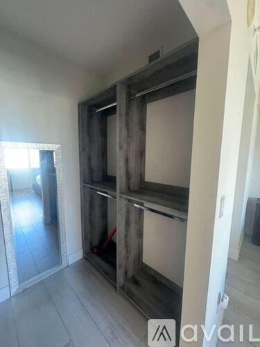 A room with a large wooden cabinet and a mirror on the wall.