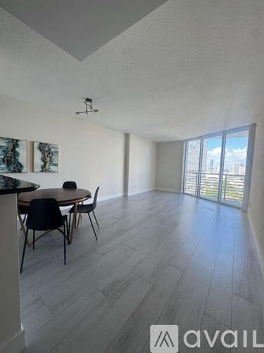 A room with a table and chairs and a painting on the wall.