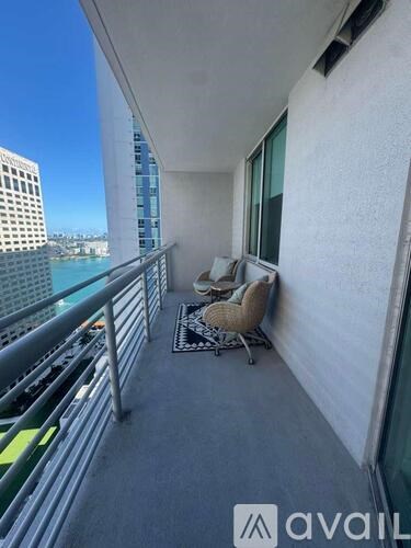 A balcony with a chair and a table with a mat on it.