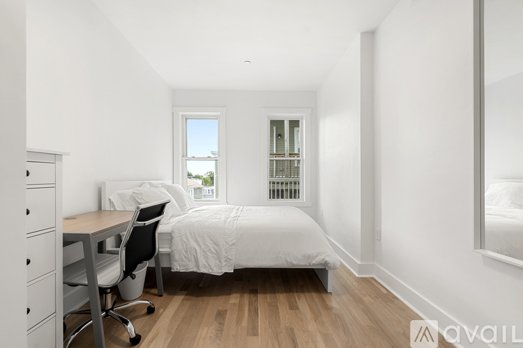 A bedroom with a bed, desk, and chair.