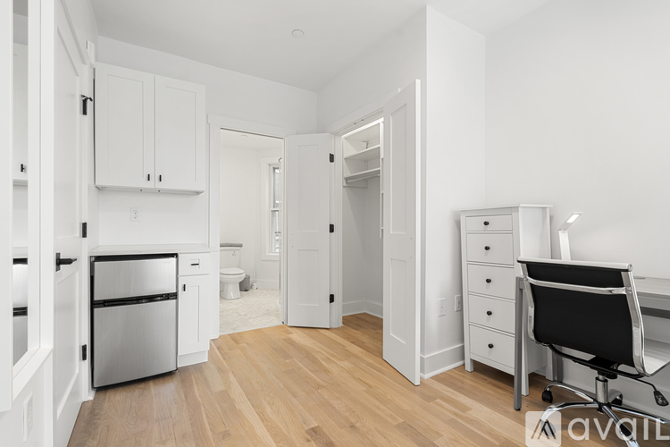 A kitchen with white cabinets and a wooden floor.
