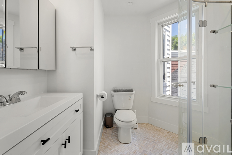 A white bathroom with a toilet, sink, and mirror.