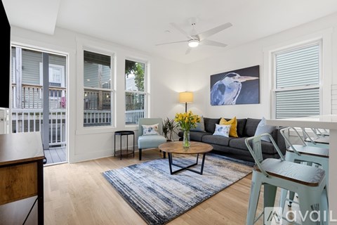 A living room with a couch, a coffee table, and a painting of a bird on the wall.