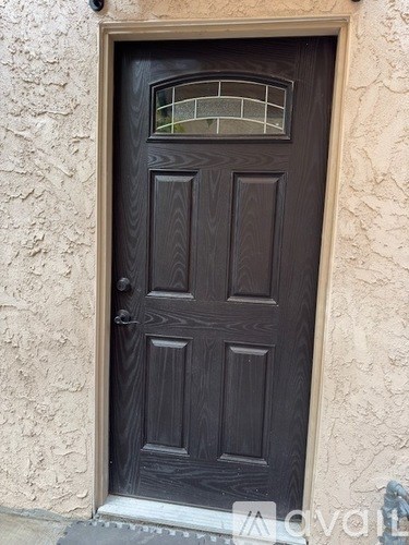 A brown wooden door with a glass panel above the handle.