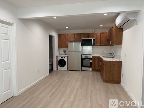 A kitchen with wooden cabinets and a white wall.