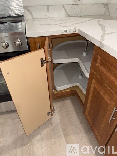 A kitchen with a white counter top and wooden cabinets.