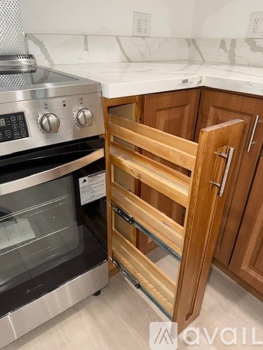 A stainless steel oven with a glass door is in a kitchen with wooden cabinets.